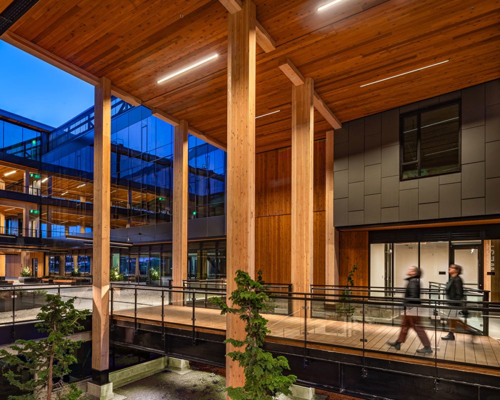 Photo of two people walking through a terrace in the open space of northlake commons. they are surrounded by the towering timber columns