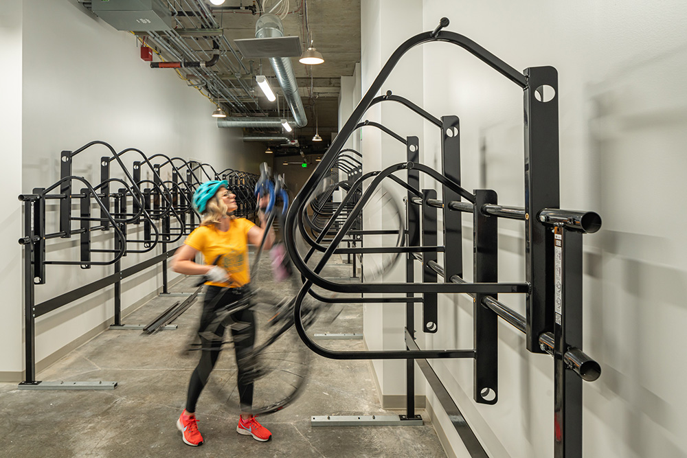 Photo of woman putting bike away in Watershed bike room