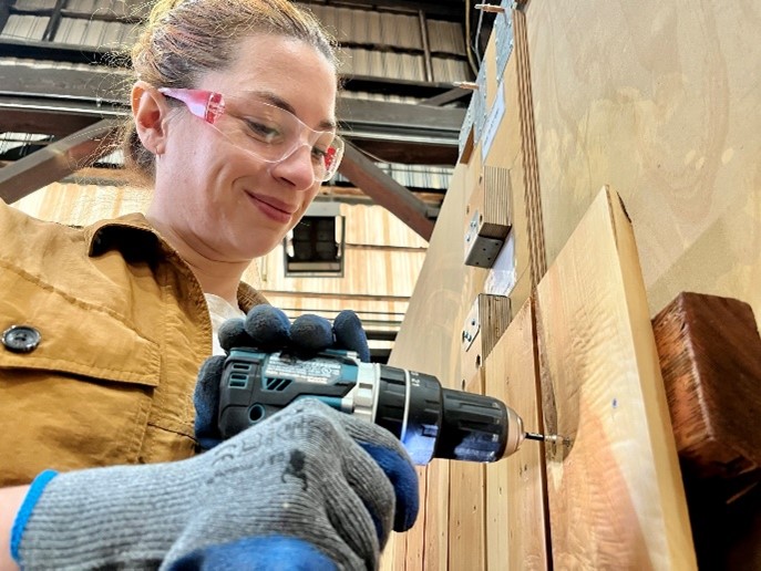 Photo of Brittany Porter screwing into a panel 