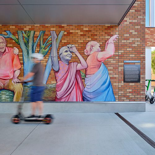 photo of a mural in the breezeway at beacon pacific village with two people walking