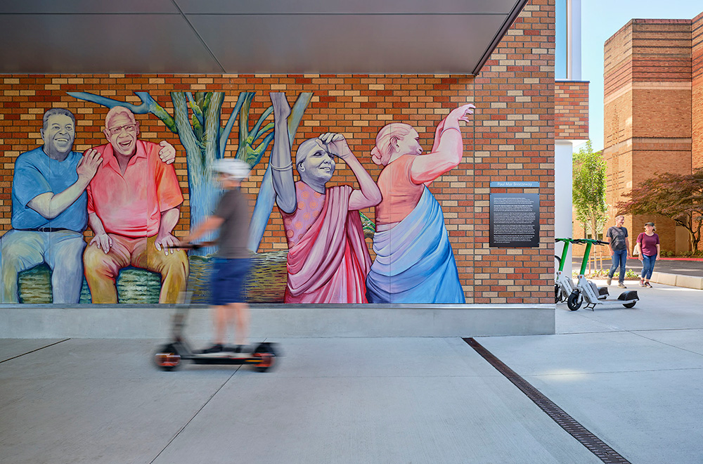 photo of a mural in the breezeway at beacon pacific village with two people walking
