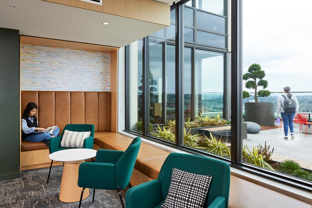 Photo of a student studying in a reading nook with windows that overlook the rooftop deck.