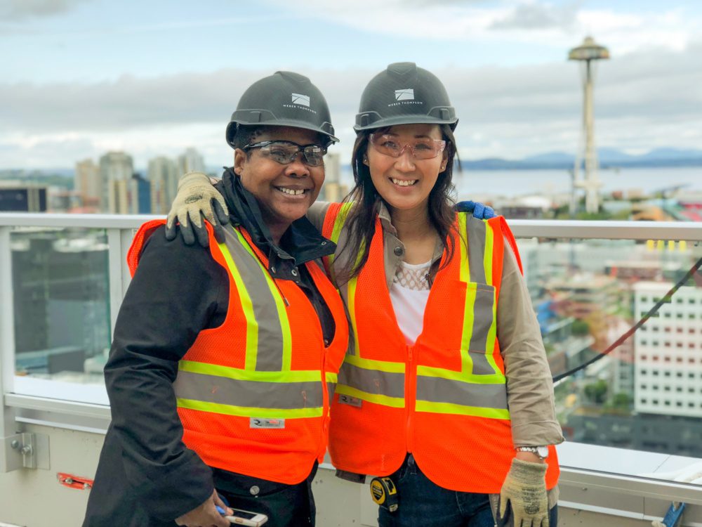 Two female WT staff in hard hats pose together