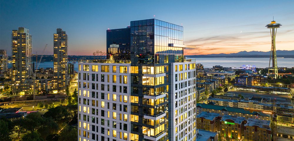 drone photo of the top of the waverly at dusk with the space needle in the background 