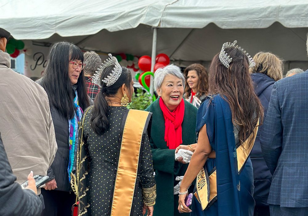 Photo of Pasty Surh O'Connell shaking hands with community members.