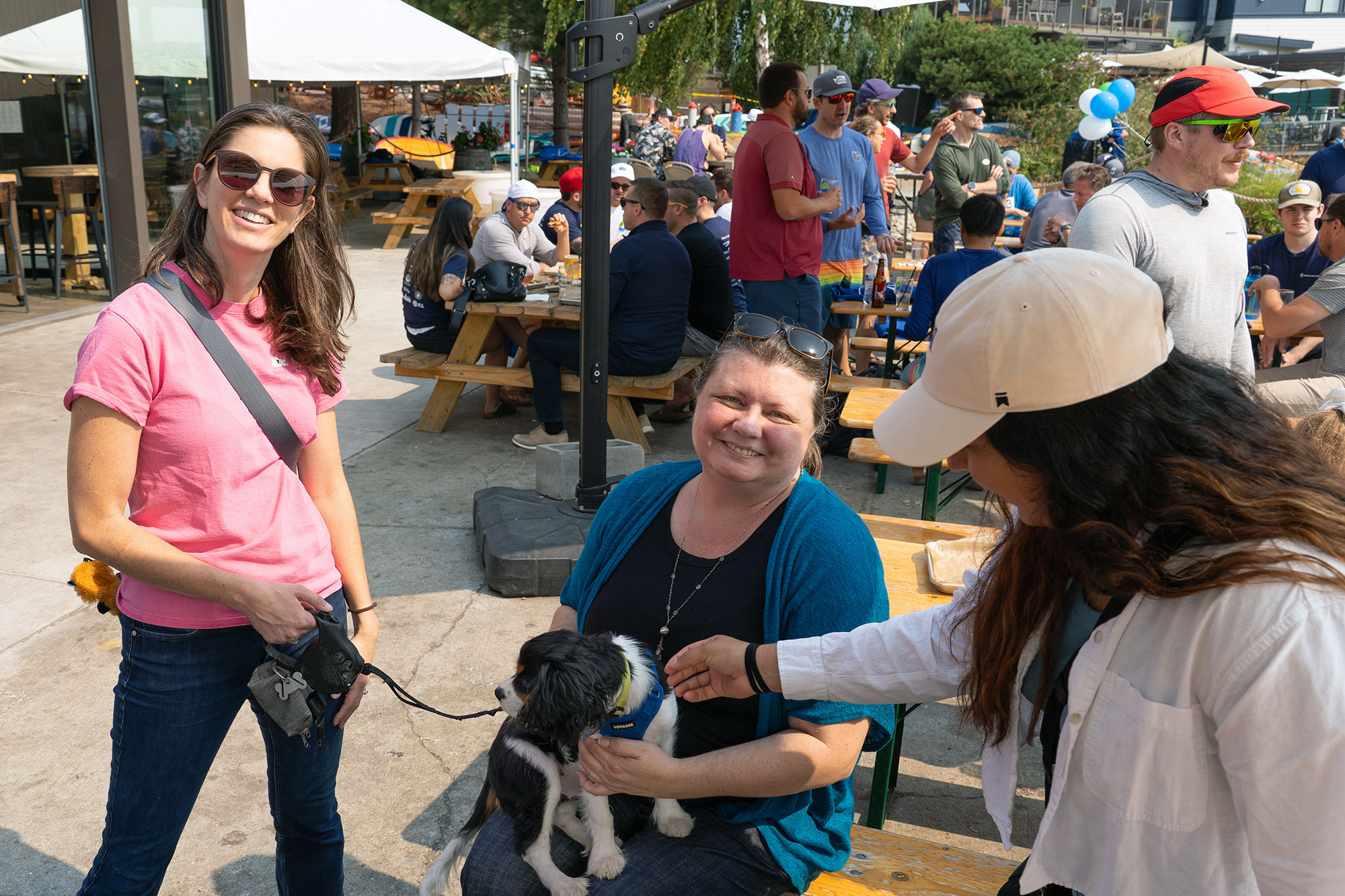 photo of weber thompson employees at an event on a sunny day, one is holding a puppy
