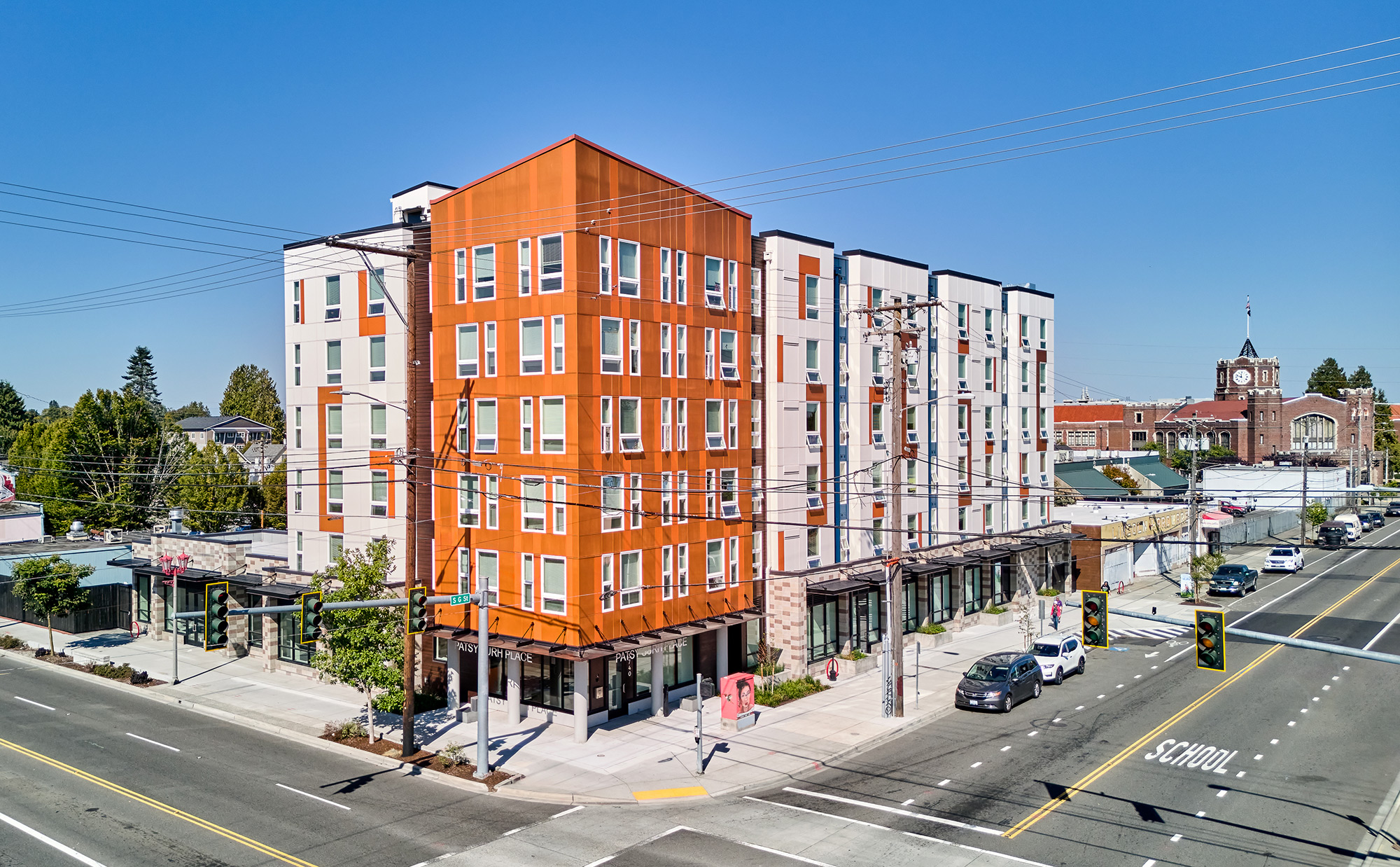 Southeast view of Patsy Surh Place with Lincoln High School in the background, streetlight, power lines, and a few cars parked by the South G Street entry