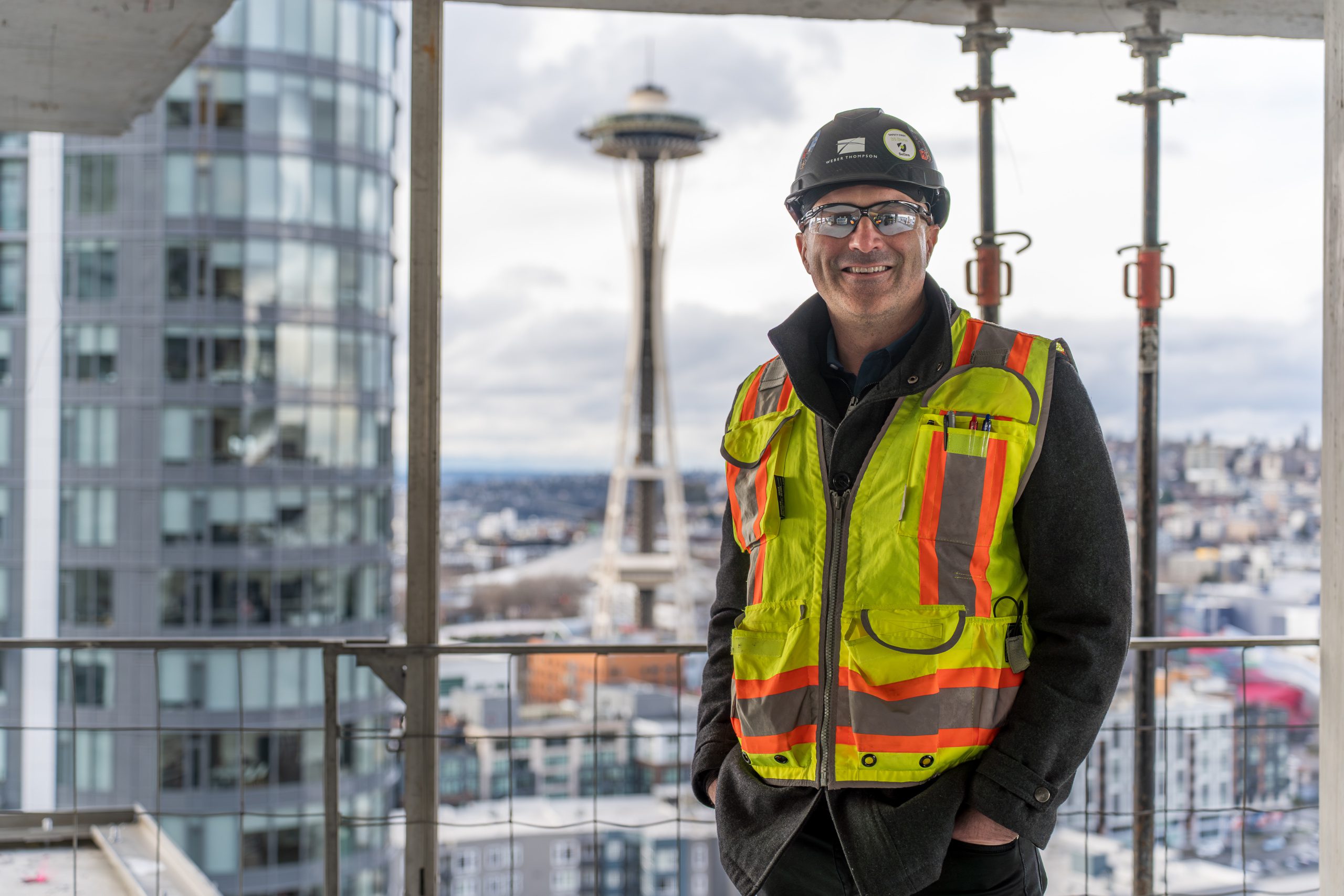 photo of construction worker at a high rise with the space needle in the background