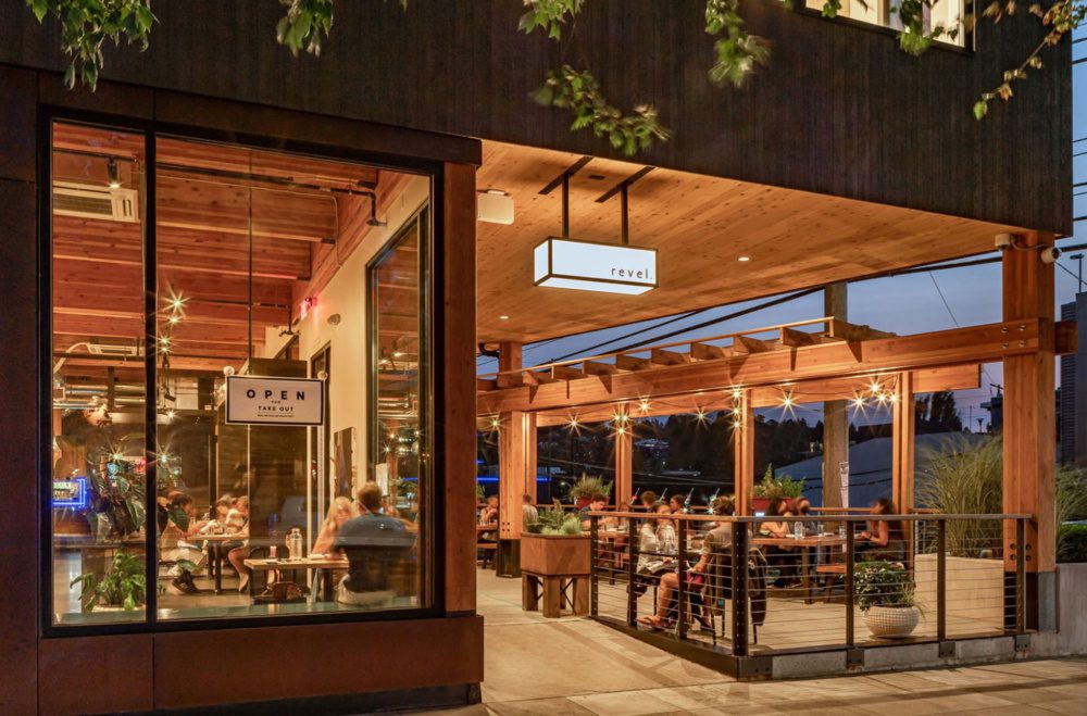 photo at night with warm lighting showing the interior and outdoor space with exposed mass timber