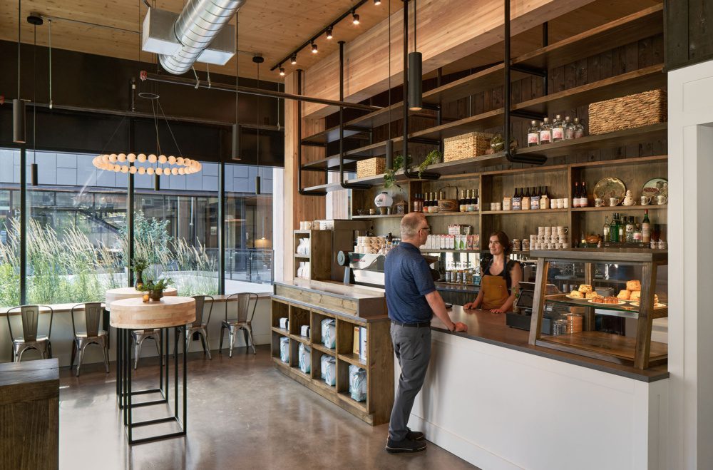 photo of a restaurant interior of a mass timber building with a man ordering food at the counter