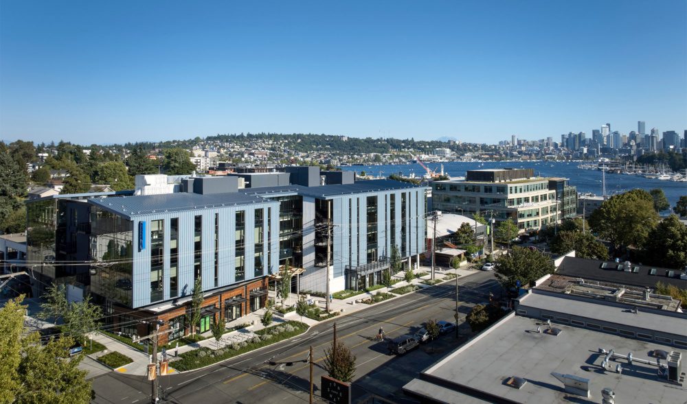 drone photo of cornerstone in fremont with the seattle skyline in the background and lake union in view