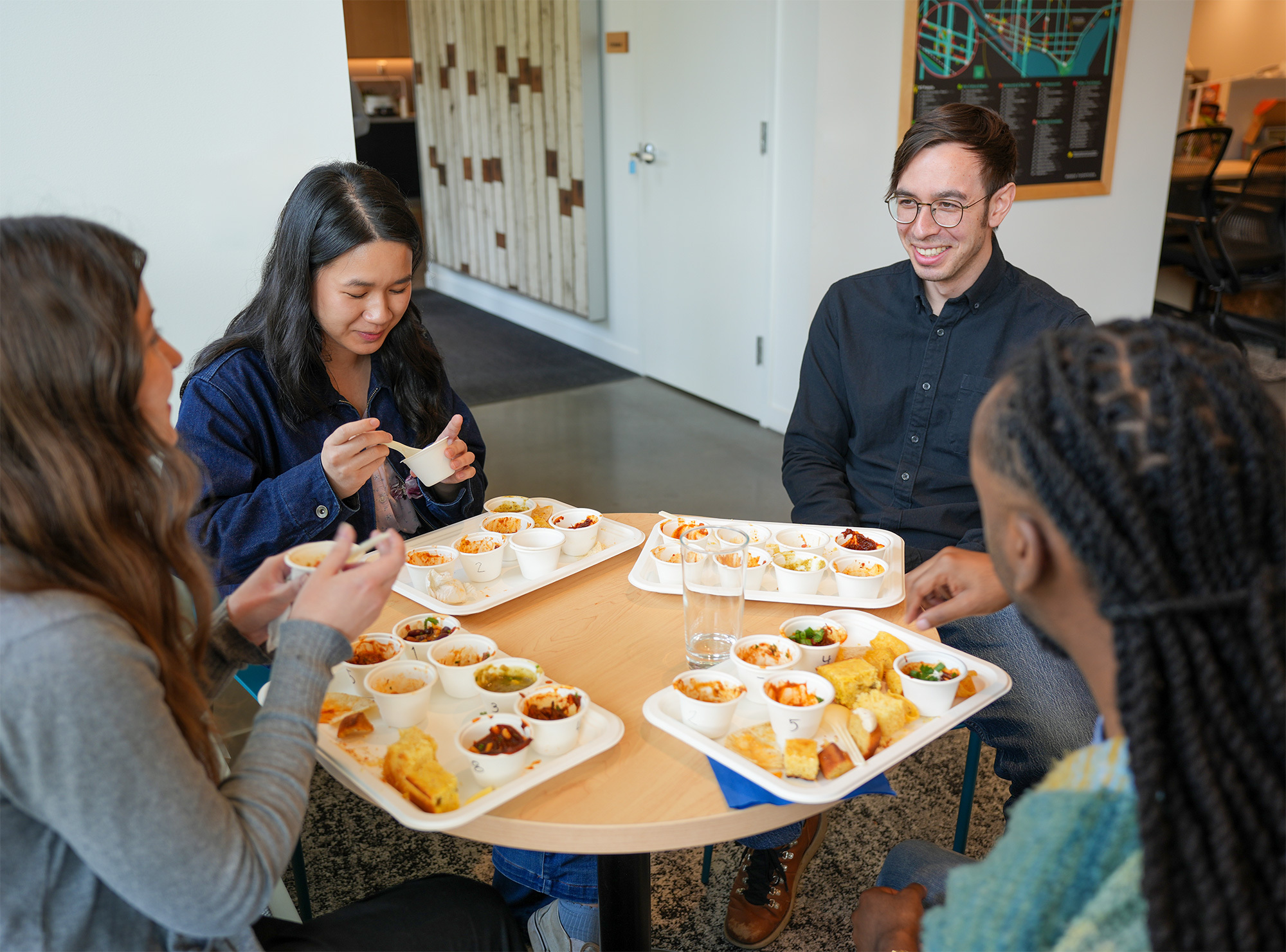 photo of staff members sitting ast a table together eating chili samples during the chili cookoff competition