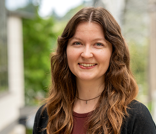 Portrait of Allison Turner taken outdoors with green foliage in the background