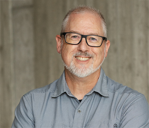 Portrait of Brooks Lockard with a textured concrete wall in the background