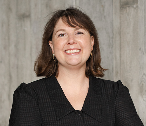 Portrait of Lauren Jones with a textured concrete wall in the background