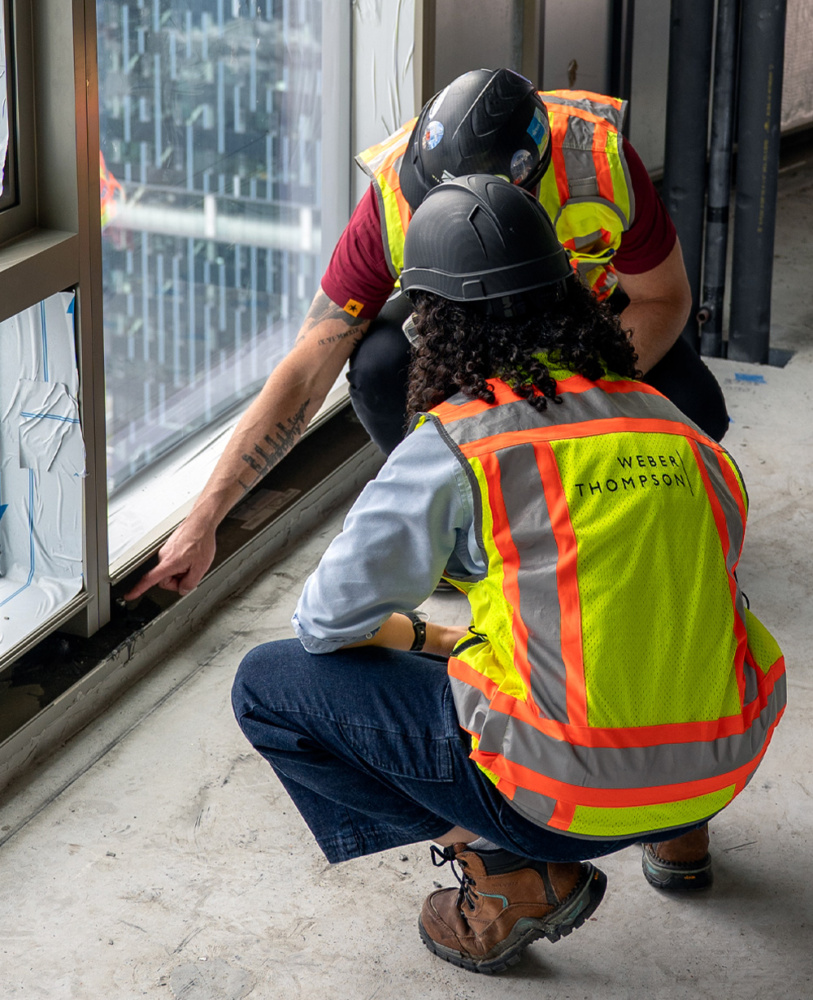 photo of two architects looking at a window detail at a construction site