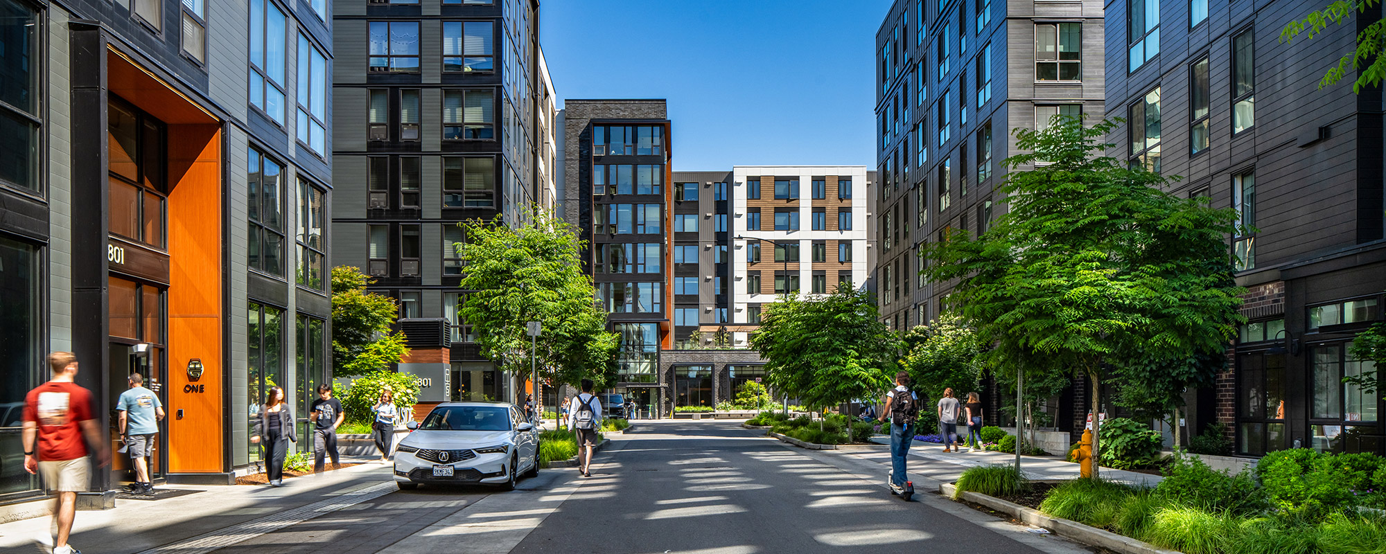 photo of trailside student housing on a sunny day with students walking around the property
